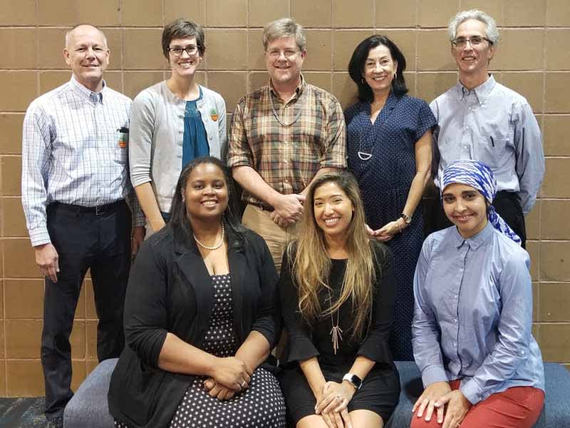 Eight AAFP Vaccine Science Fellowship participants pose in front of wall.