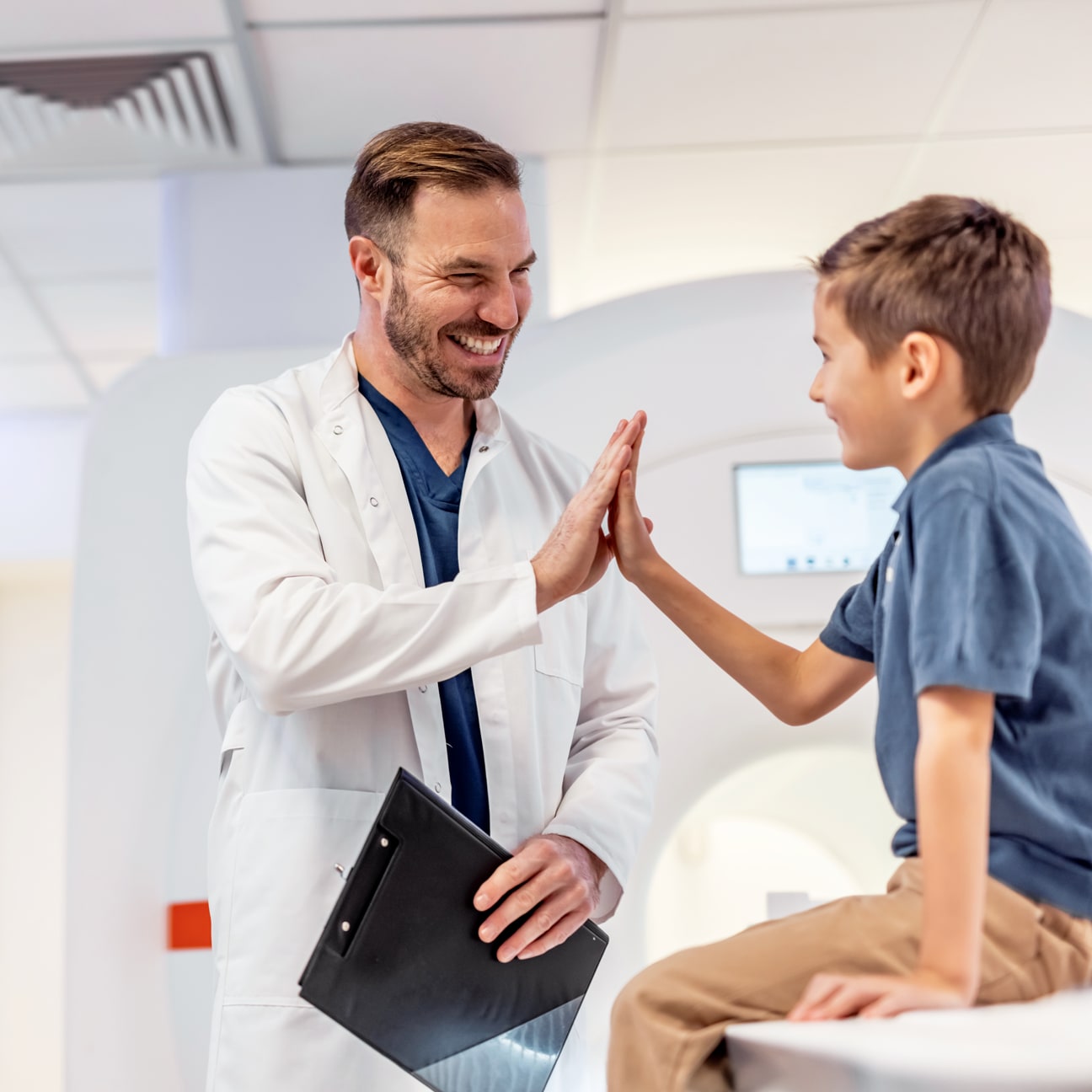 Image of physician high-fiving an adolescent patient.