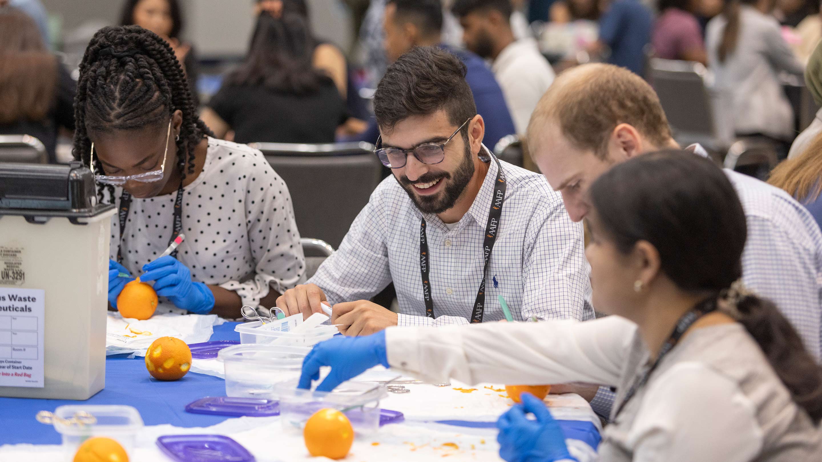 Medical students practicing clinical skills on oranges at an AAFP hands-on workshop.
