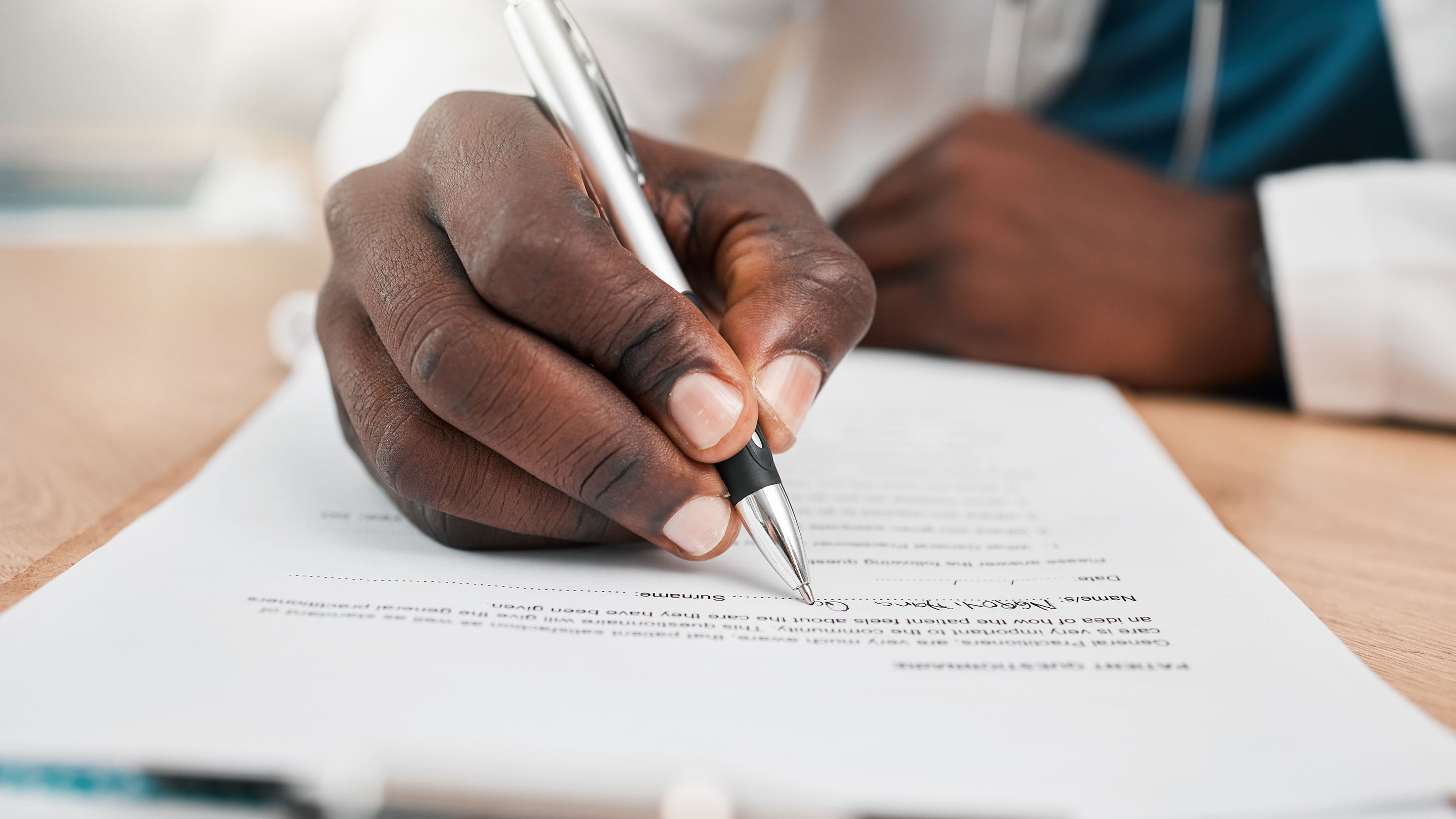 Close-up of a doctor signing a contract.