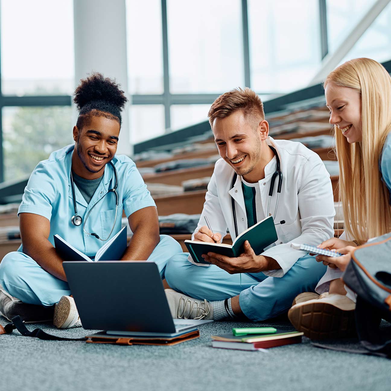 three doctors sitting on the ground in a virutal meeting or on-going education.