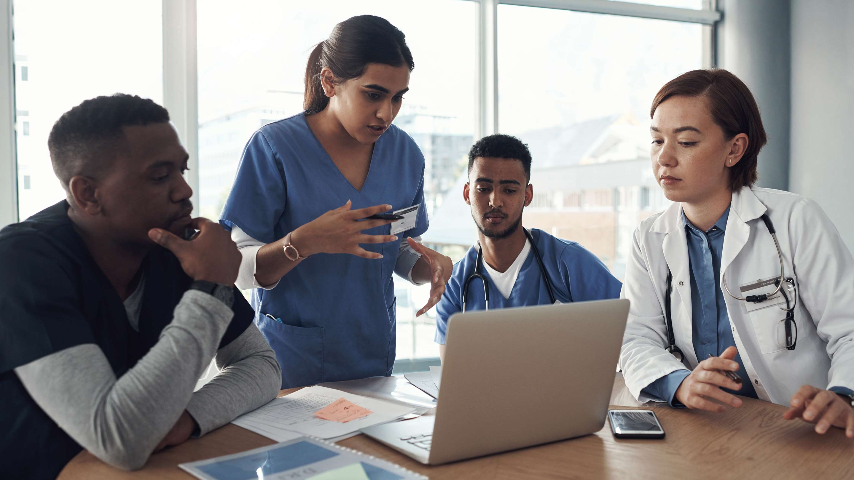 Teamwork in meeting with computer, presentation and idea for solution in medical residency.
