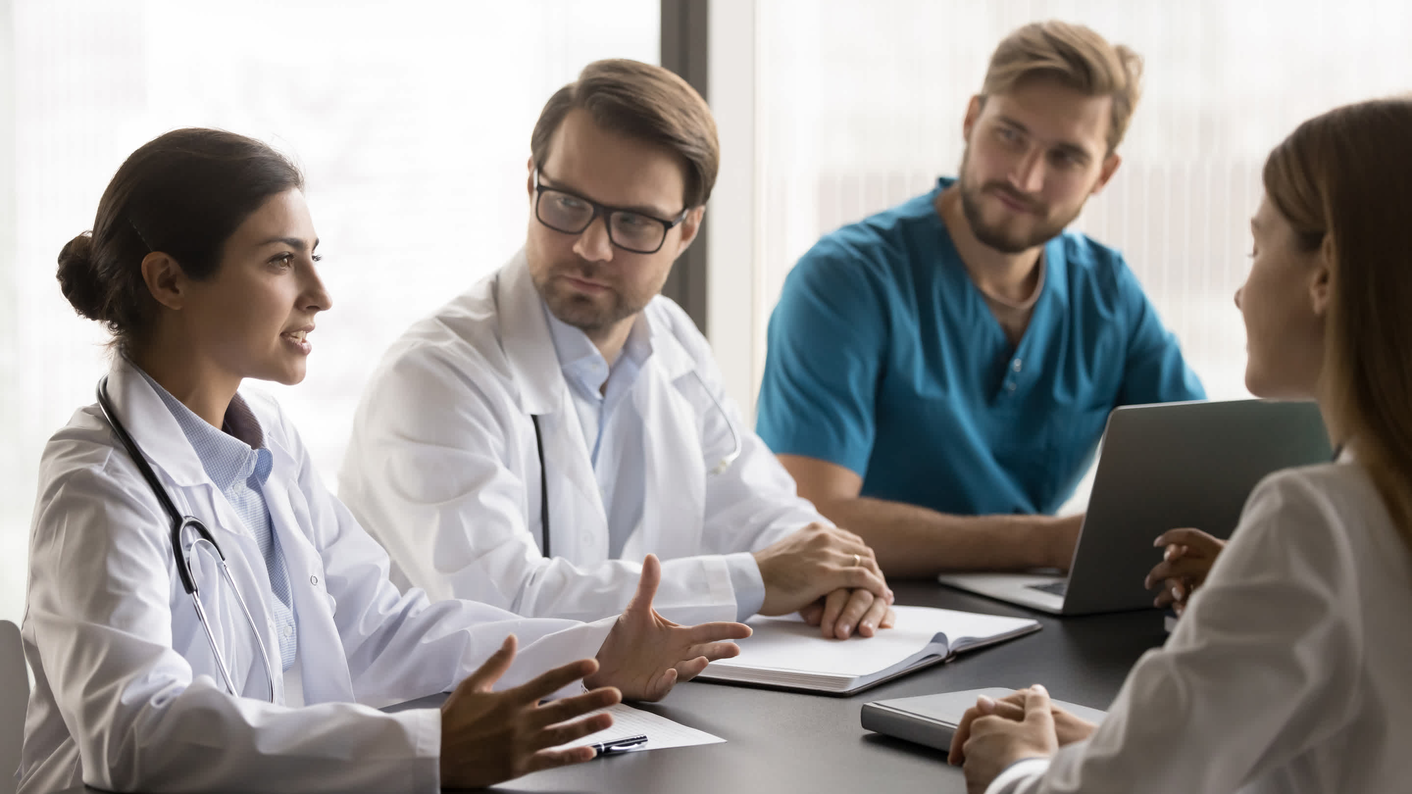 doctors sitting around a table discussing payment models