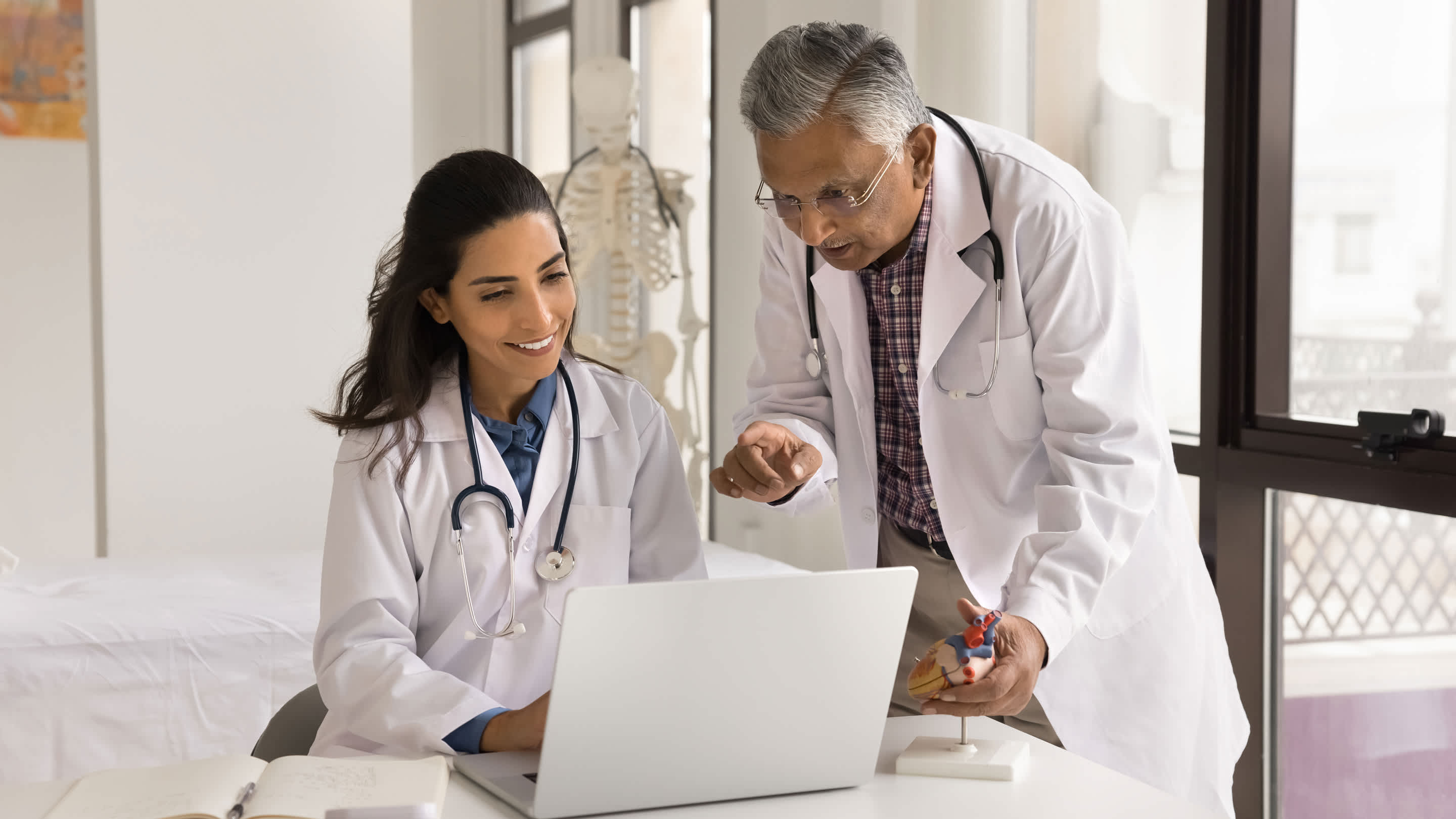 Two clinicians review data on laptop