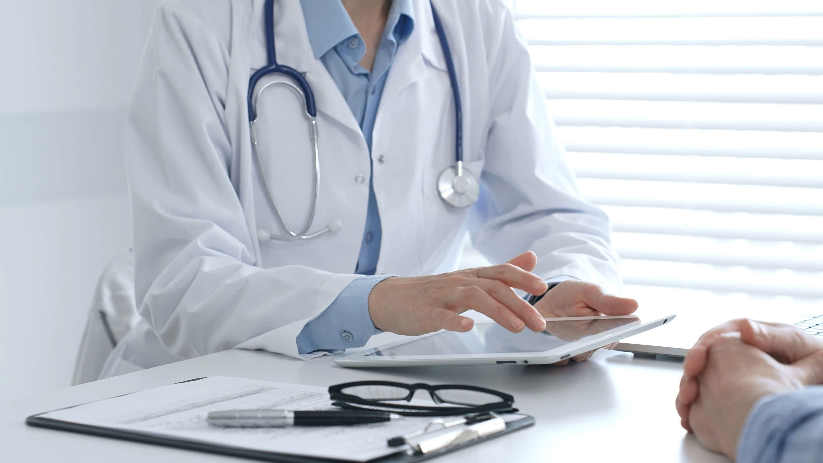 Physician reviews patient chart on tablet