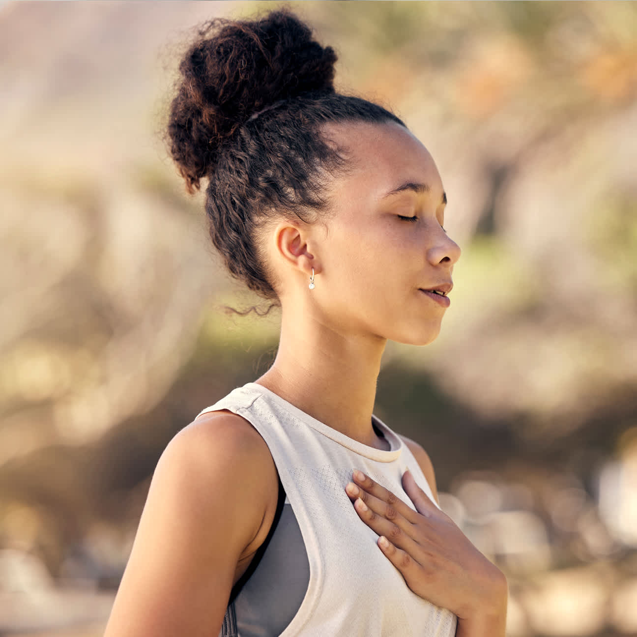 Student deep breathing with hand on chest, for meditation and wellness.
