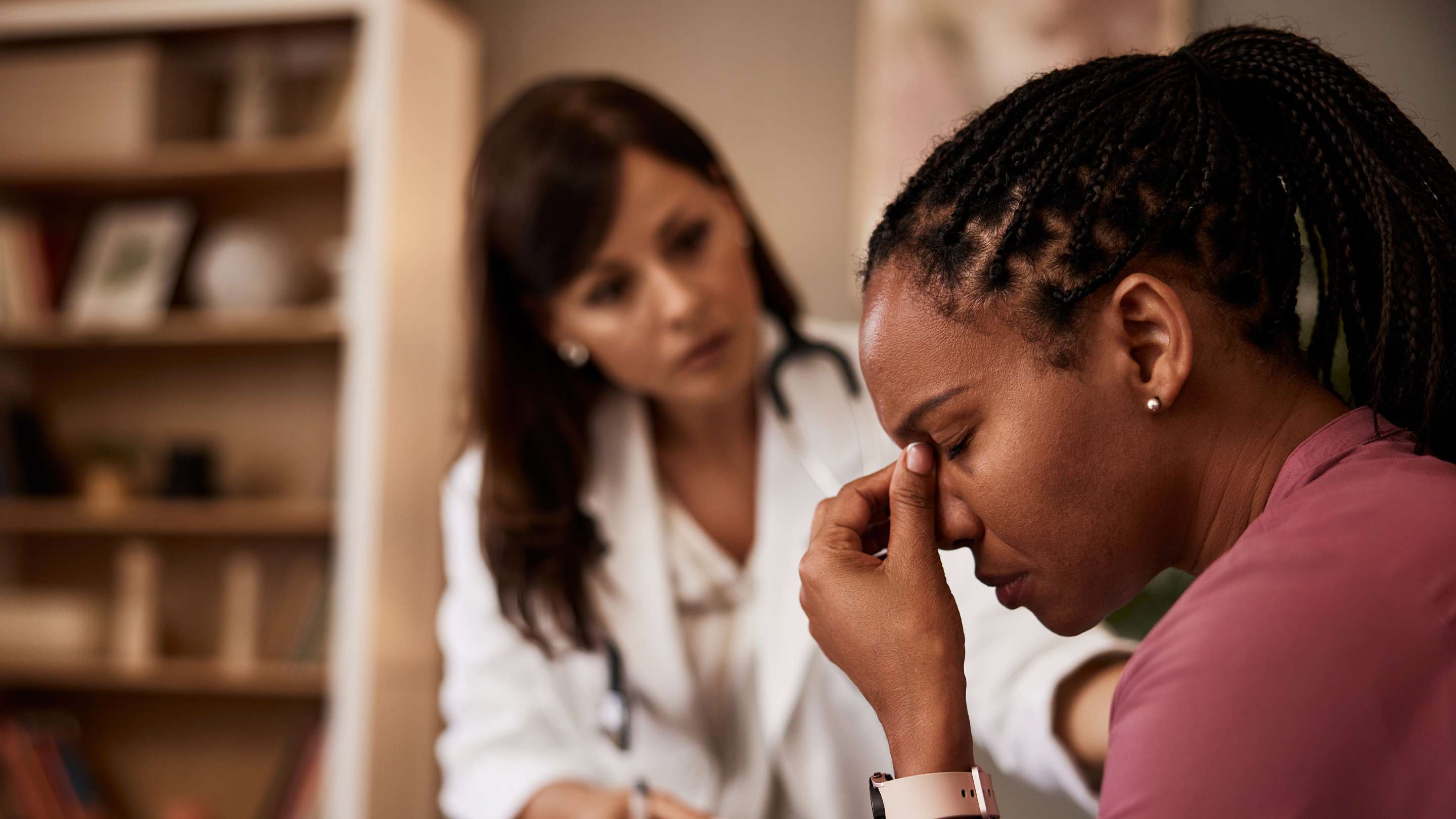 A female family physician delivering difficult news to a patient.