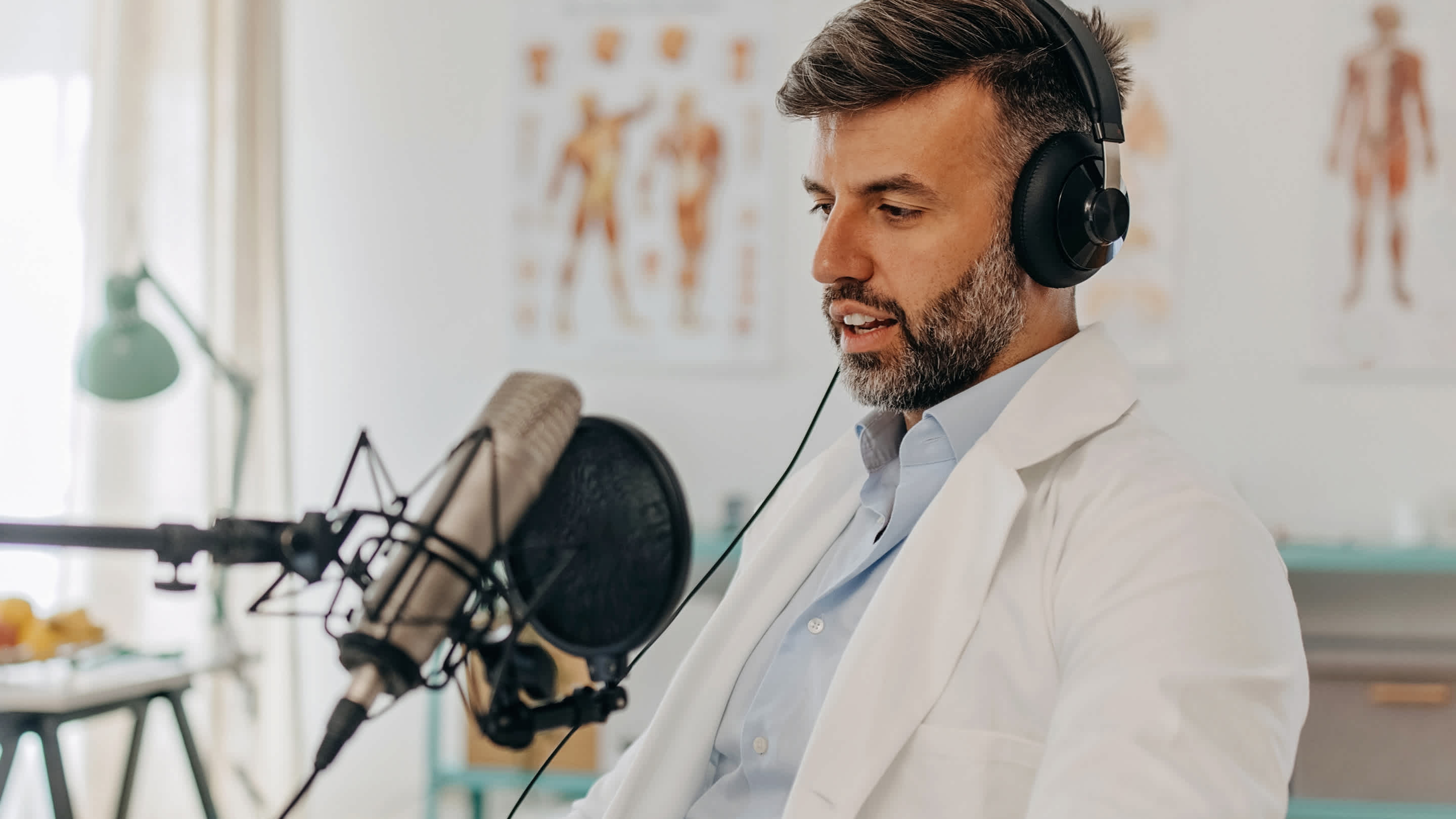 Family Physician sitting at a microphone.