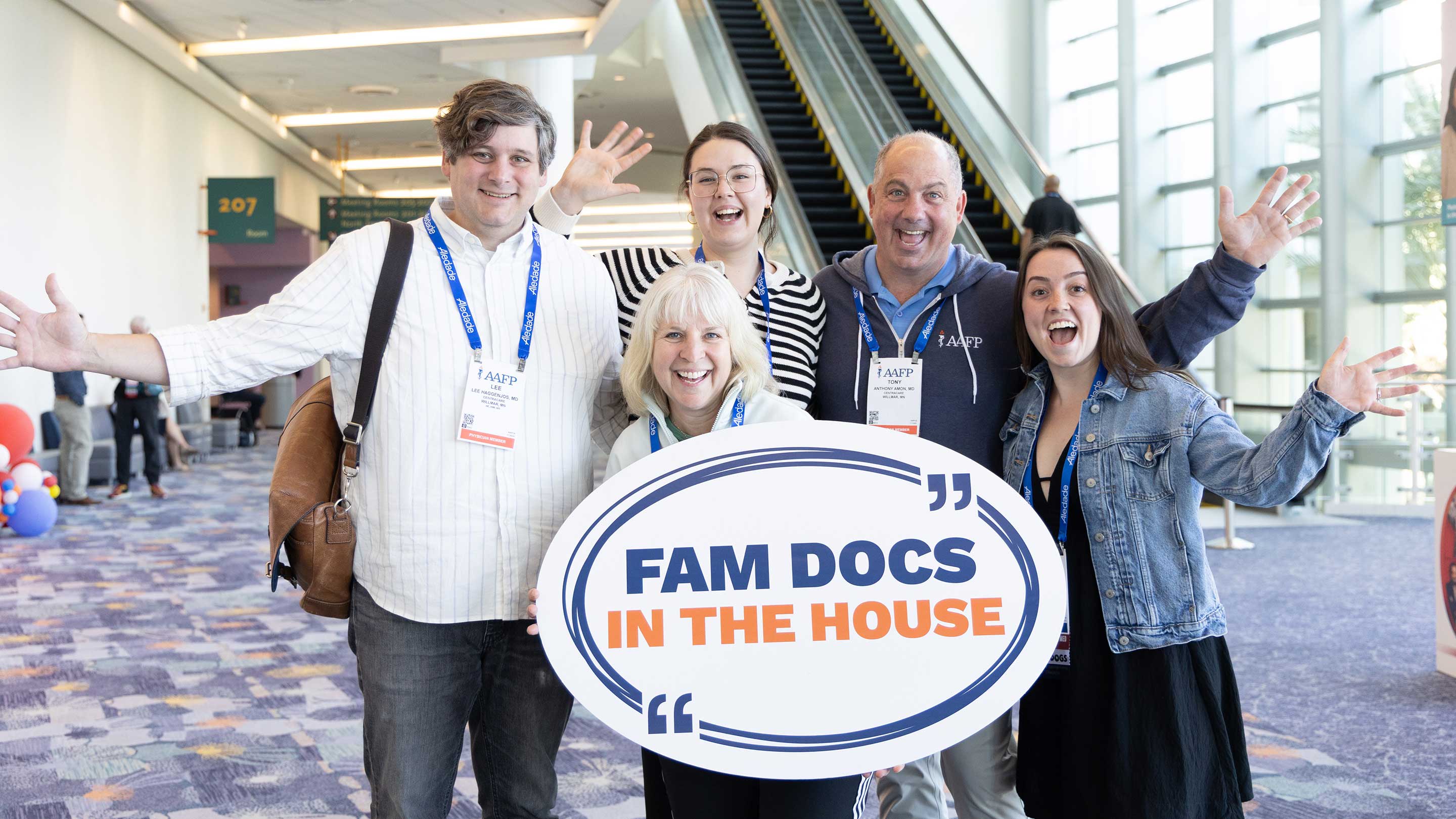 Attendees posing with photo prop at AAFP event.