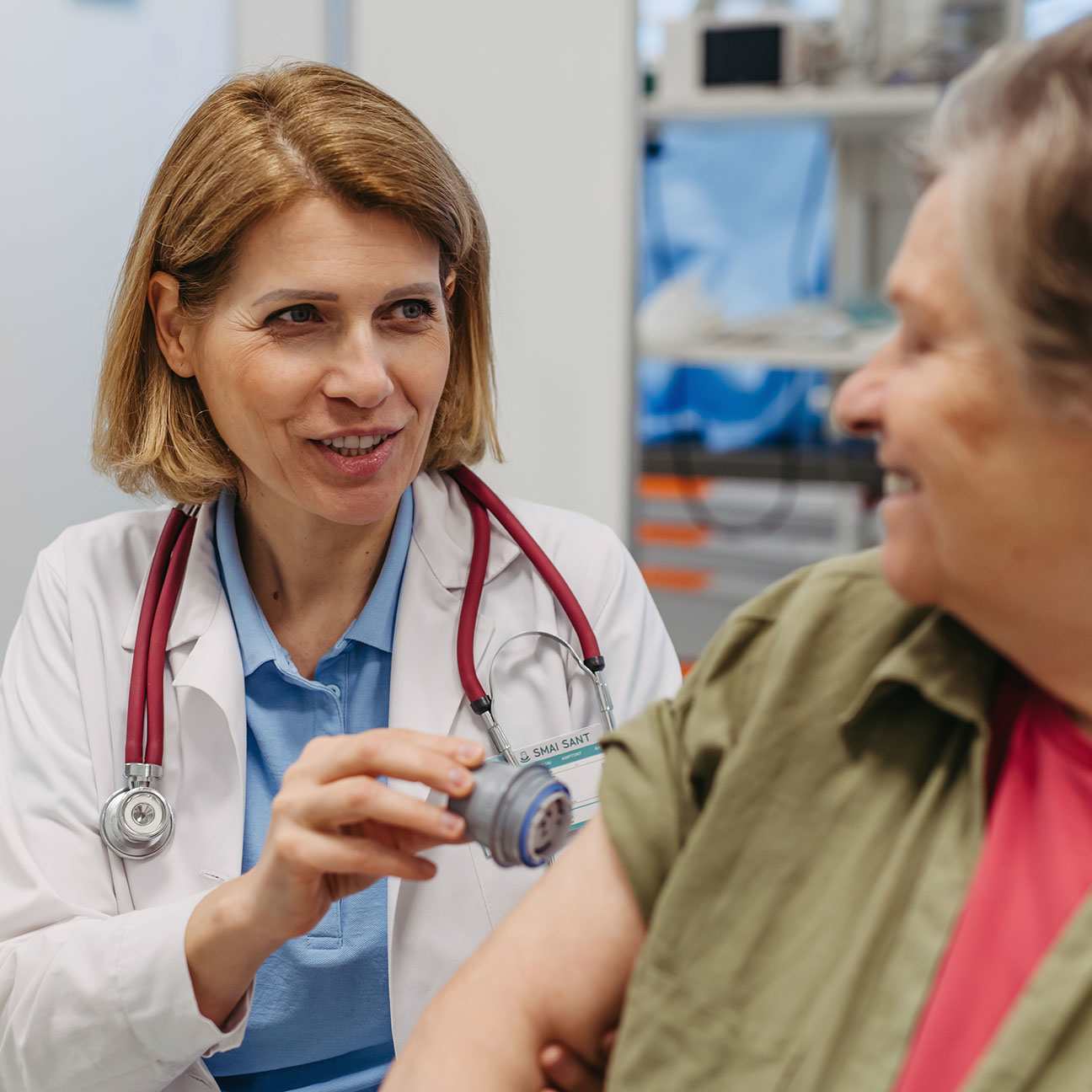 A woman doctor applies a CGM sensor to a senior patients arm.